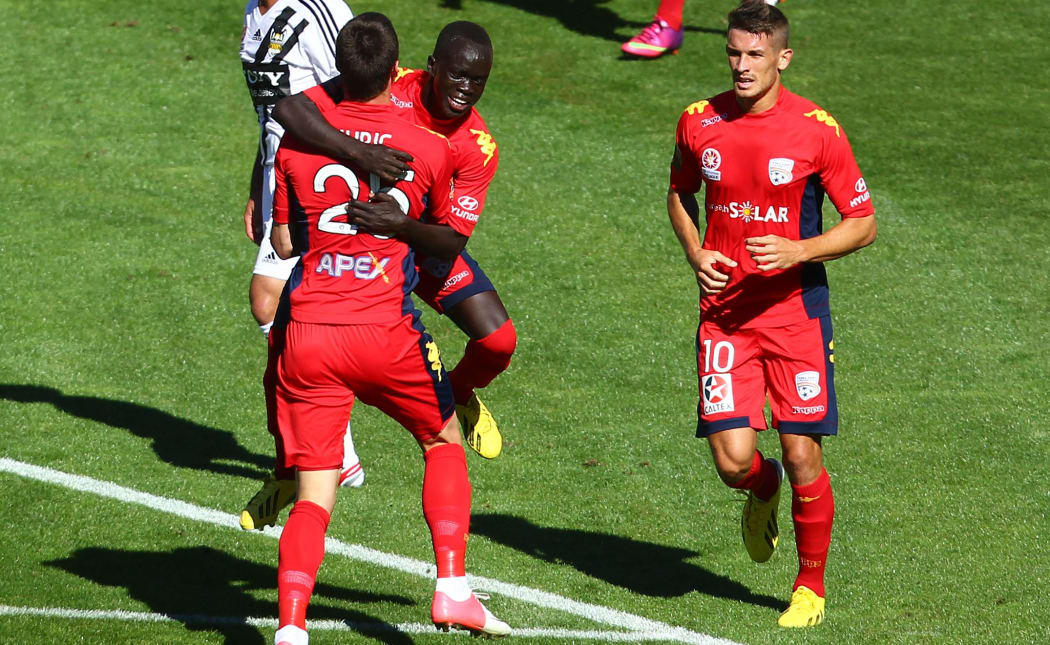Adelaide United players celebrate a goal.