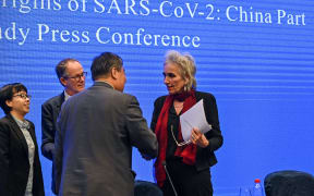 Liang Wannian shakes hands with Marion Koopmans (right) as Peter Ben Embare looks on after a press conference to wrap up a visit by an international team of experts from the World Health Organization (WHO) in  Wuhan.