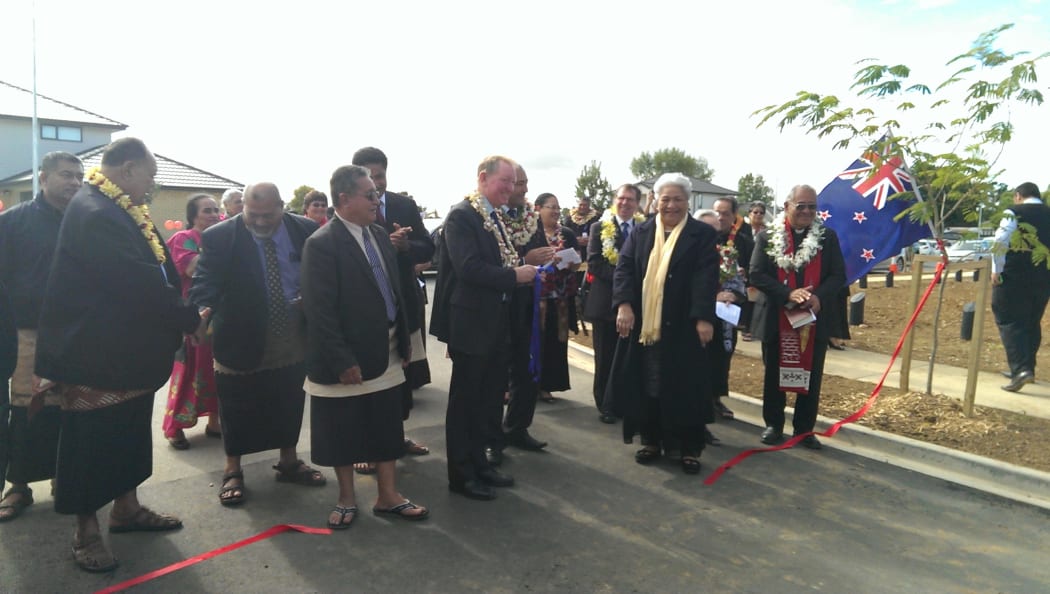 Nick Smith cuts the ribbon at the opening of the housing project in South Auckland.