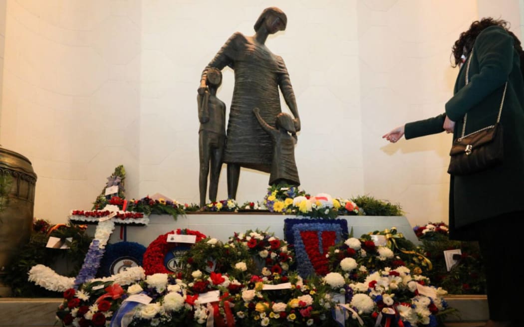 Wind loudly buffeted the hall where wreaths were laid near a statue named 'Mother and Children', representing families left behind during wartime.