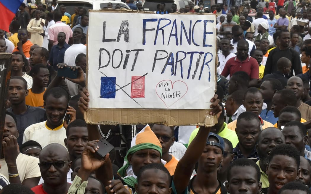 Protesters hold an anti-France placard during a demonstration in Niger's capital Niamey on 3 August, 2023. Niger's junta said the same day that it was scrapping military pacts made between Niamey and France, following its coup the week prior.