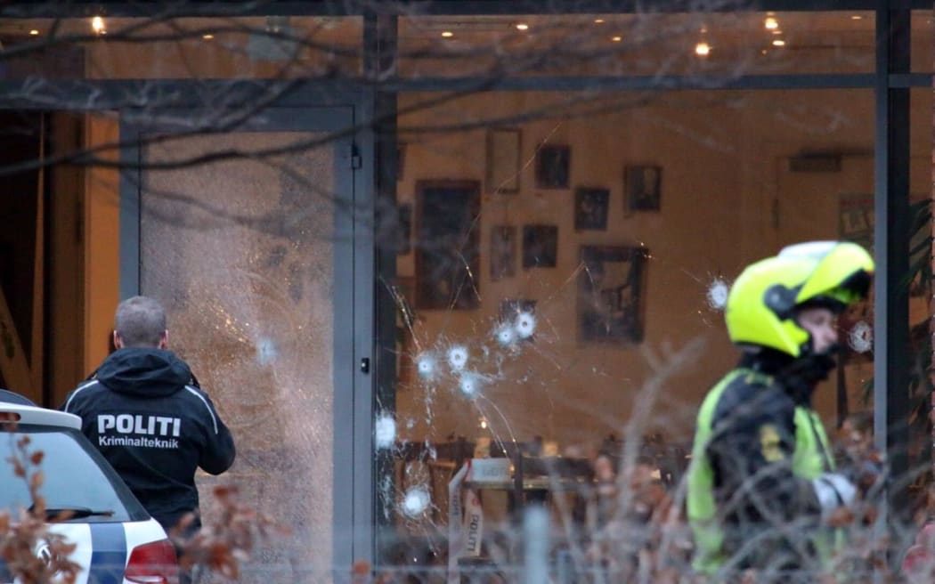 Policemen secure the area around a building in Copenhagen where shots were fired.