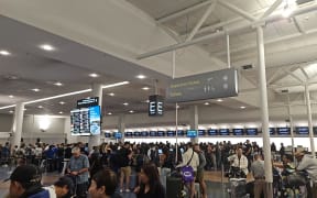 Passengers queue at Auckland International Airport after their flight to Santiago, Chile was cancelled. The plane they were meant to fly on experienced a "technical problem" that saw 13 people hospitalised, one with serious injuries.