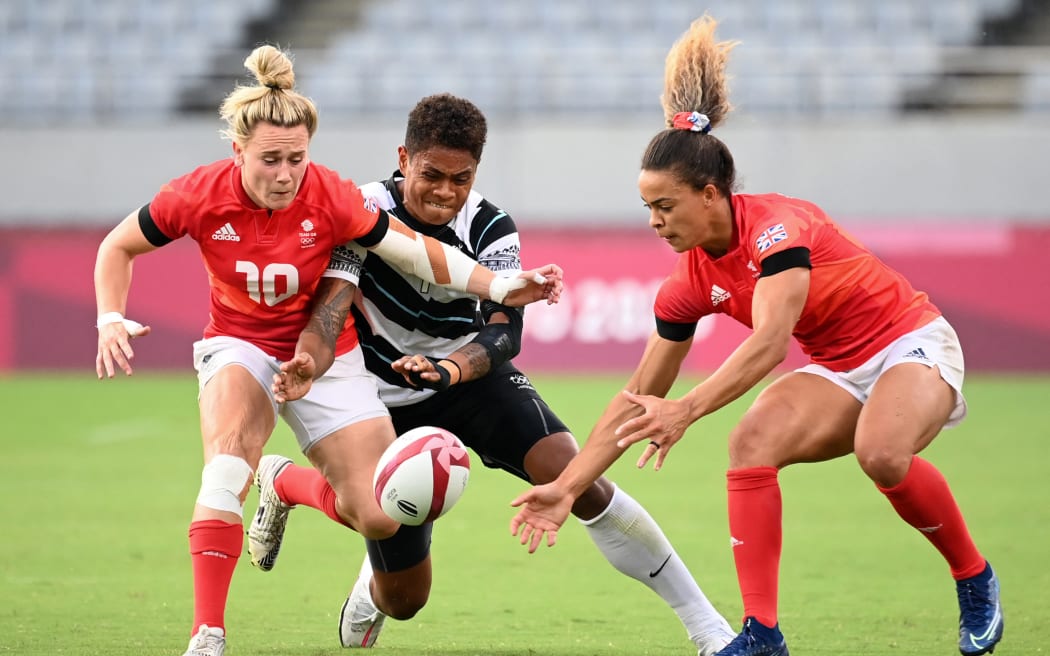 Two British players fight for the ball with Fiji's Reapi Uluinasau in the women's bronze medal rugby sevens match at the Tokyo Olympics 2021.