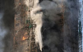 Flames engulf bamboo scaffolding across multiple buildings on November 26, 2025.