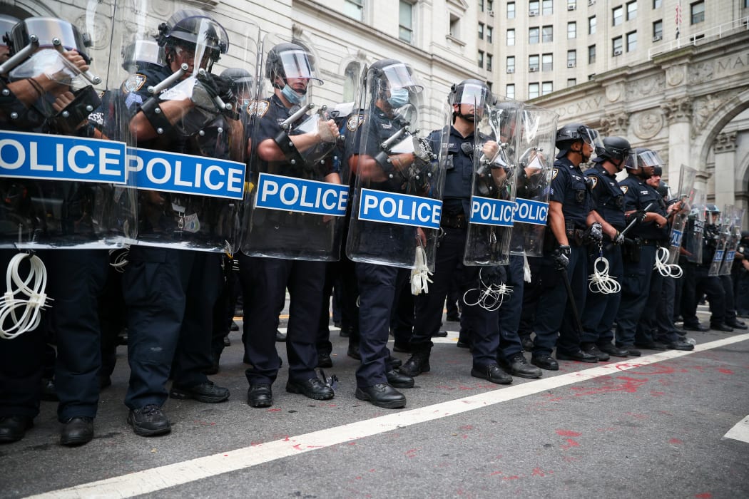 Police officers stand guard during Black Lives Matter protest as protesters locked down the streets by New York's City Hall and Police Plaza.