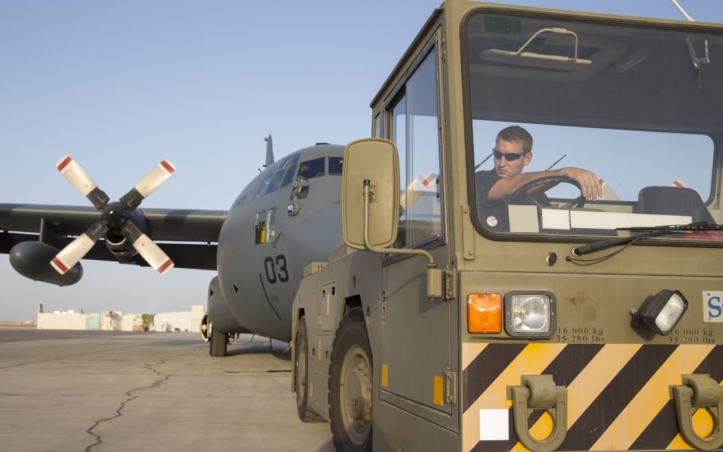 The C-130 Hercules aircraft is towed to its position.