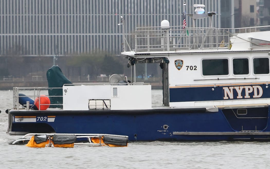 JERSEY CITY, NEW JERSEY - APRIL 10: A crashed helicopter is seen floating in front of an NYPD boat on the Hudson River on April 10, 2025 in Jersey City, New Jersey. All six people on board were killed after a helicopter believed to be carrying a family of tourists crashed into the Hudson River on Thursday afternoon.   Michael M. Santiago/Getty Images/AFP (Photo by Michael M. Santiago / GETTY IMAGES NORTH AMERICA / Getty Images via AFP)