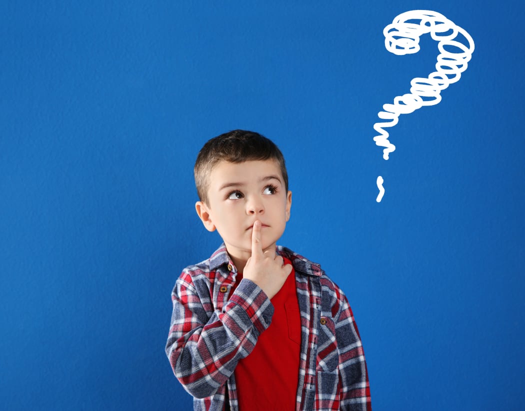 Emotional boy with drawing of question mark on blue background