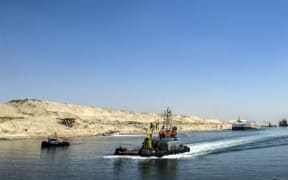 A picture taken on July 29, 2015 shows boats crossing the new waterway at the new Suez Canal in the Egyptian port city of Ismailia, east of Cairo.