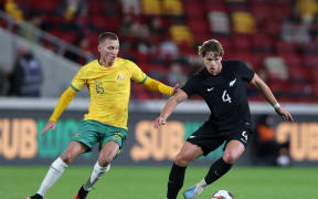 Nando Pijnaker of New Zealand is challenged by Mitchell Duke of Australia.