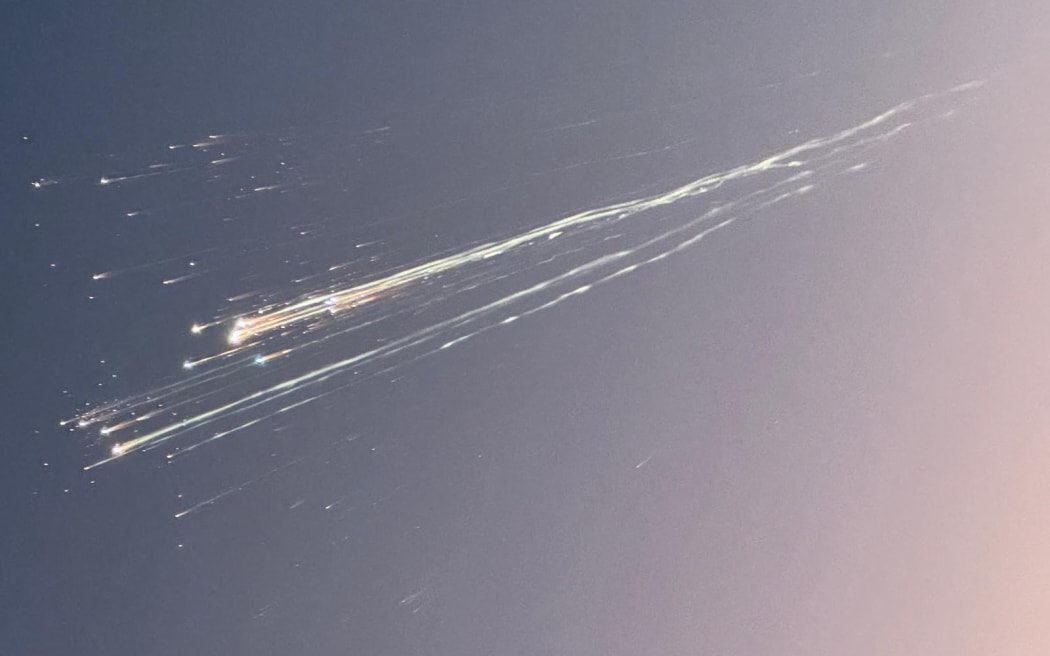 In this handout image courtesy of Greg Blee, debris from the SpaceX Starship is seen in the sky near Providenciales, Turks and Caicos on January 16, 2025. Hours after Jeff Bezos's Blue Origin nailed its first-ever orbital mission, SpaceX seized back the spotlight on January as its latest test of Starship, its gargantuan next-generation megarocket, ended with the upper stage dramatically disintegrating over the Atlantic. (Photo by Greg Blee / HANDOUT / AFP) / RESTRICTED TO EDITORIAL USE - MANDATORY CREDIT "AFP PHOTO /  GREG BLEE / HANDOUT" - NO MARKETING NO ADVERTISING CAMPAIGNS - DISTRIBUTED AS A SERVICE TO CLIENTS