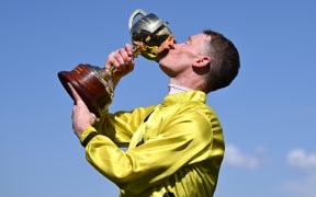 Jockey Mark Zahra kisses the Melbourne Cup after riding Without A Fight to victory.
