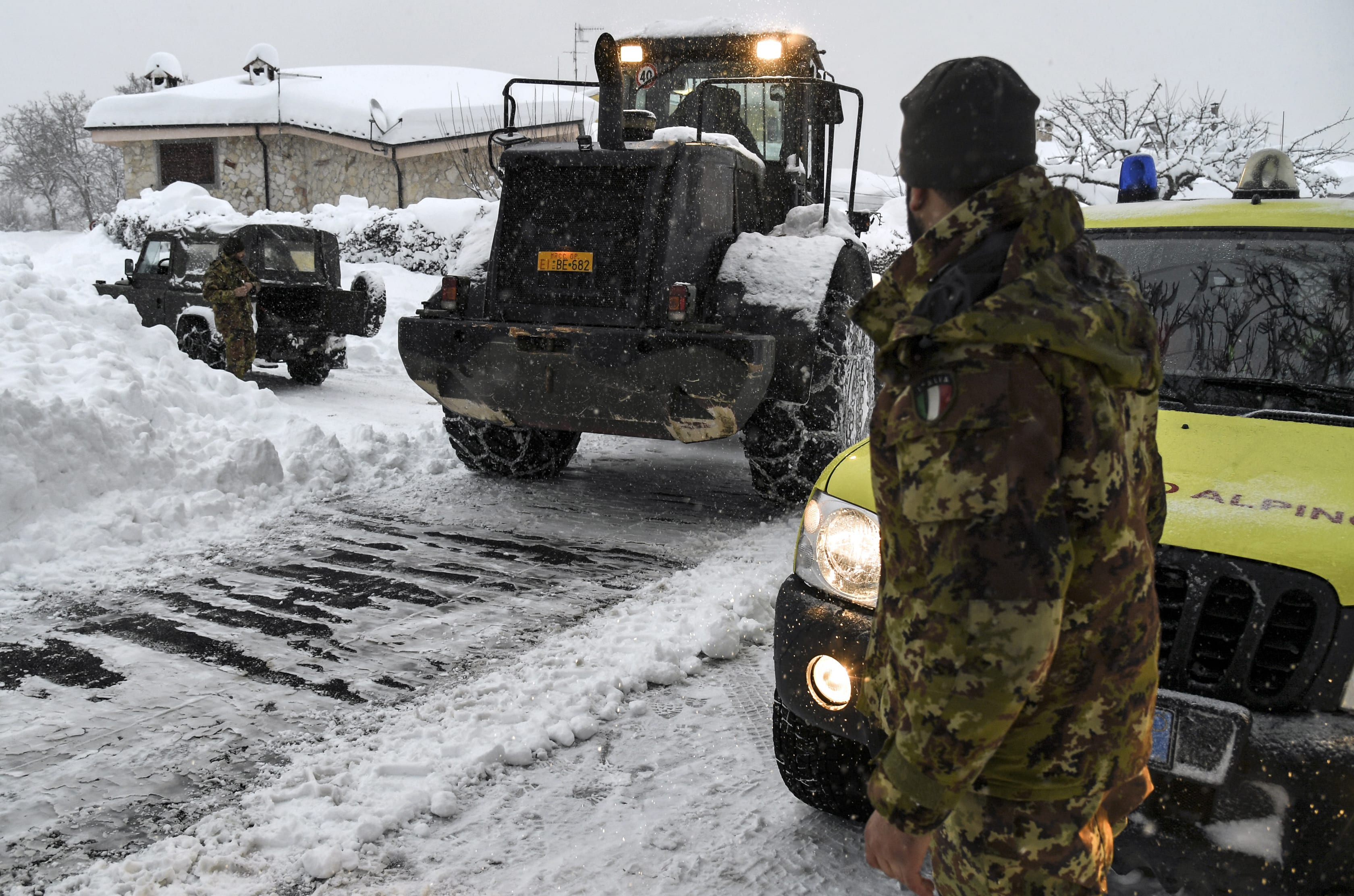 Civil defence and military vehicles clear snow from a central street of Aringo near Montereale in Italy after the earthquakes.