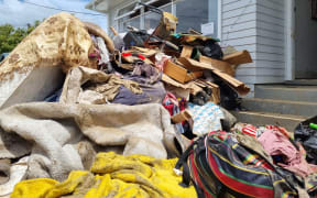 Vasiti Pele and her husband Siosaia's sodden belongings piled outside their West Auckland home after their house flooded.