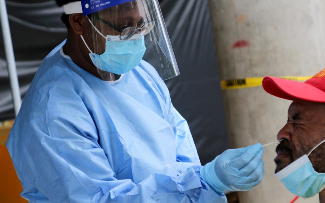 A health worker takes a swab from a man at a Covid-19 testing centre in Port Moresby. Rates of testing in PNG are incredibly low.