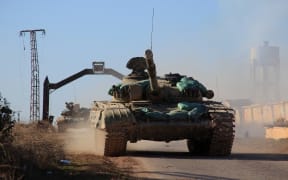 Syrian government forces' tanks drive in the village of Tal Jabin, north of the embattled city of Aleppo, as they advanced to break a three-year rebel siege of two government-held Shiite villages, Nubol and Zahraa, and take control of parts of the supply route on February 3, 2016.