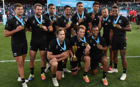 The New Zealand men's sevens team with the World Cup trophy.