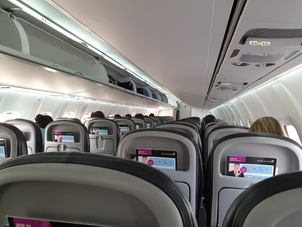 Passengers sitting at a distance from each other on an Air New Zealand flight from Christchurch to Queenstown on 14 May,