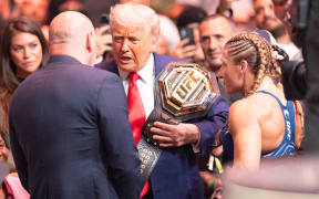 President Donald Trump congratulates Kayla Harrison after she wins a UFC belt in Newark, New Jersey.