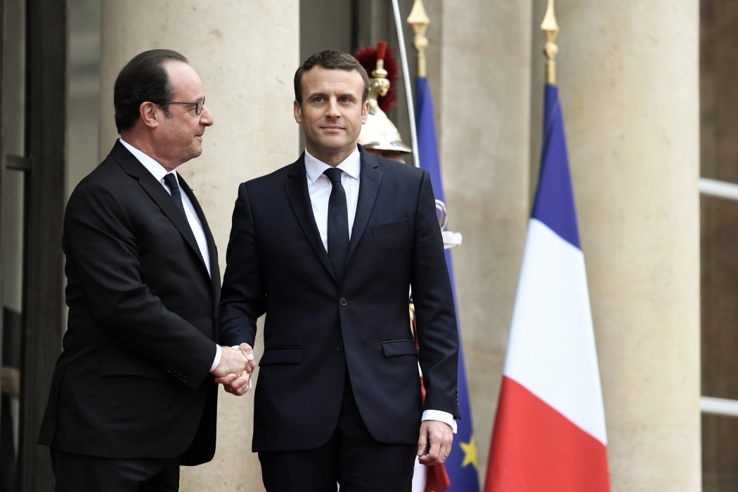 Emmanuel Macron (right) is welcomed at the Elysee presidential Palace by his predecessor François Hollande.
