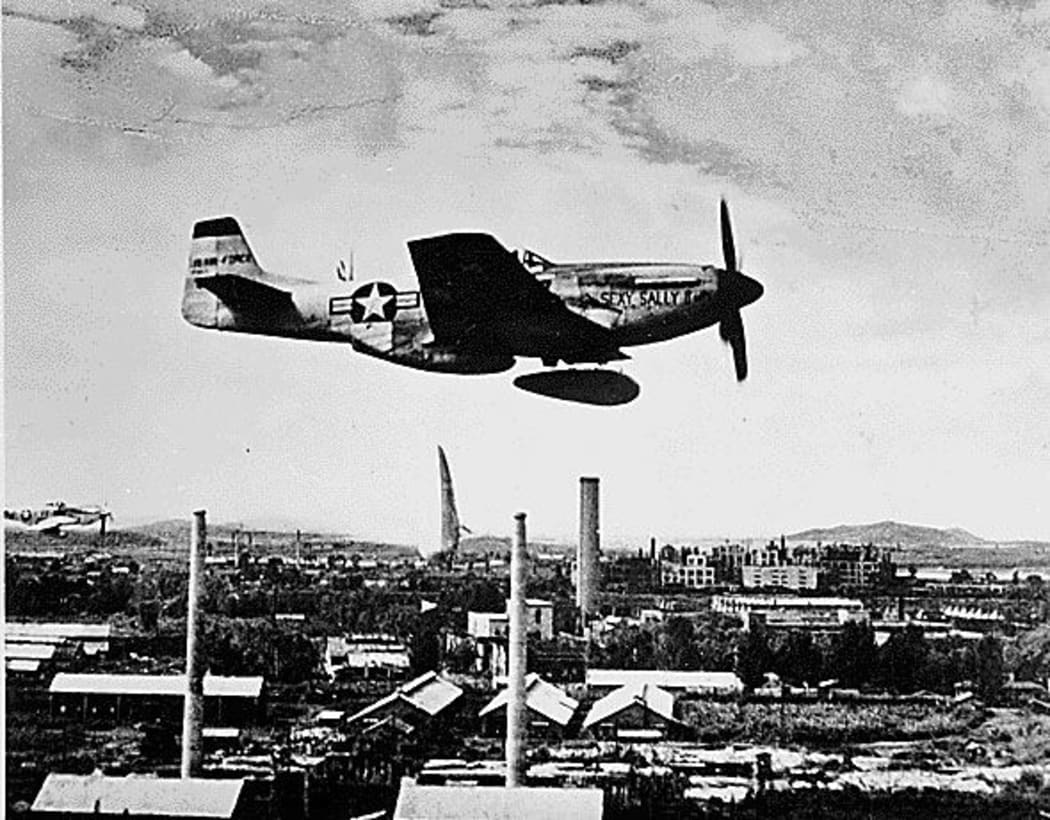 This August,1951 photo shows an P-51 "Mustang" a split second after it dropped two napalm fire bombs over a North Korean target.
