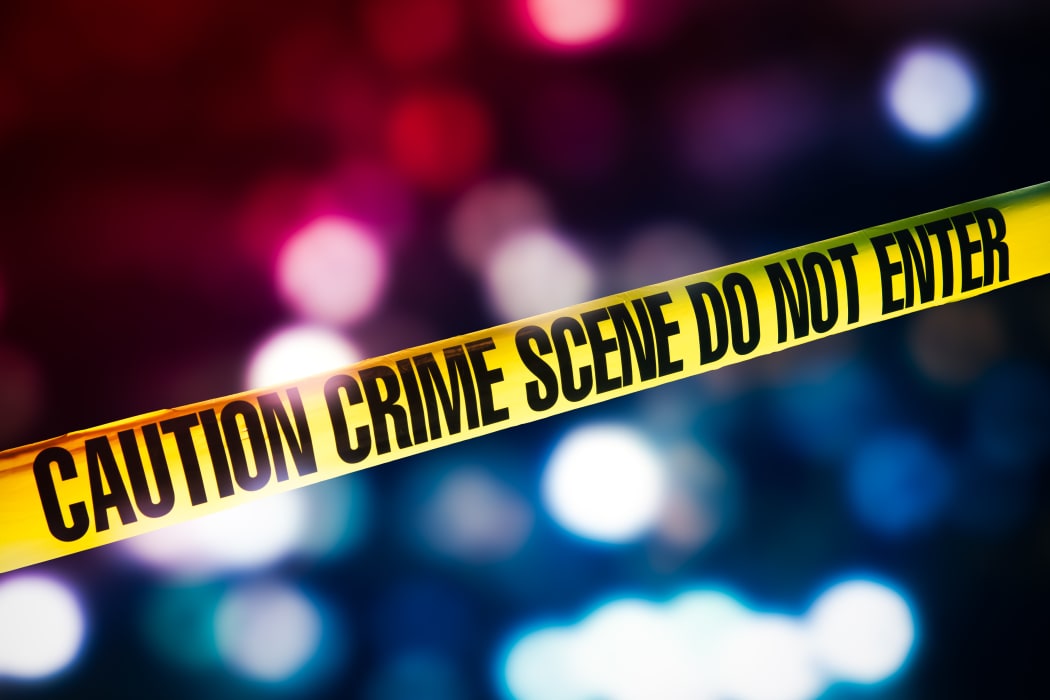 high contrast image of Crime scene tape with red and blue lights on the background