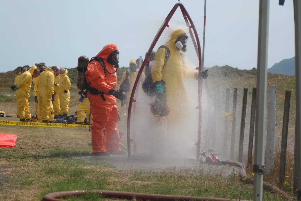 Recovery teams wash off toxic residues after their mission to Whakaari/White Island.