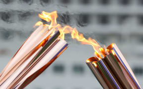Olympic flame is passed from a torch to another torch, Japan, 2021.
