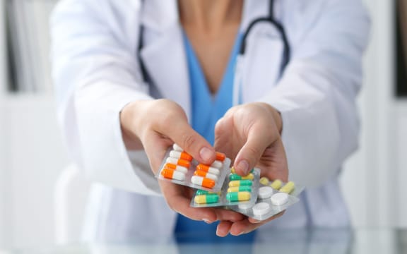 Female doctor hand holding pack of different tablet blisters closeup. Life save service, legal drug store, prescribe medicament, blood pressure, disease healing concept.