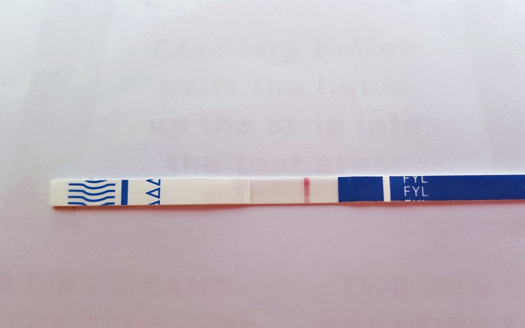 A fentanyl testing strip shows a positive result.
