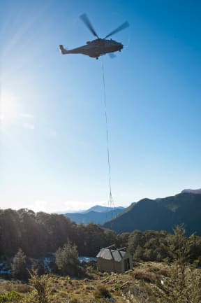 A 1700 kilogram hut, in danger of sliding into mountain bush, has been airlifted from from an active slip to stable ground in Mount Richmond Forest Park in Marlborough.