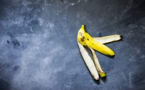 Banana peel on the concrete background.