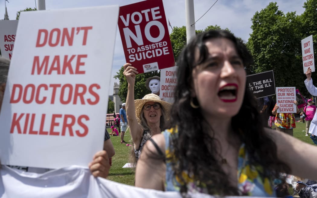 Protesters against a change in the law on assisted dying hold placards during a demonstration outside The Palace of Westminster, home to the Houses of Parliament in central London, on 20 June, 2025, as MPs hold a knife-edge vote on whether to allow assisted dying for terminally ill.