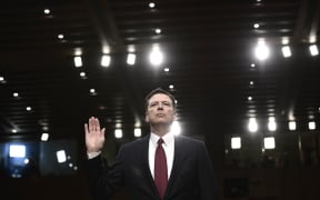 Former FBI Director James Comey takes the oath before testifying to the Senate Intelligence Committee.