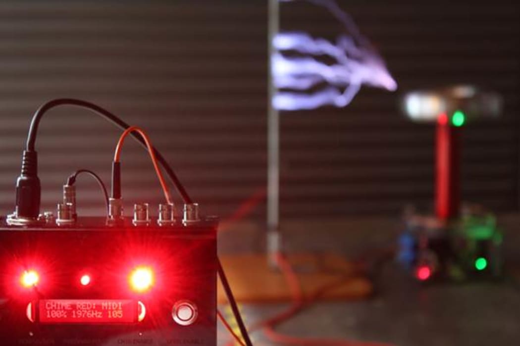 The lightning arcs produced by the Tesla coils are controlled by the Chime Red box pictured in front. The faster the coil is fired, the higher the pitch of the resulting sound.