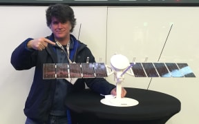 New Zealand scientist Duncan Young with a model of the Europa Clipper spacecraft in early 2022, pointing to a REASON radar antenna.