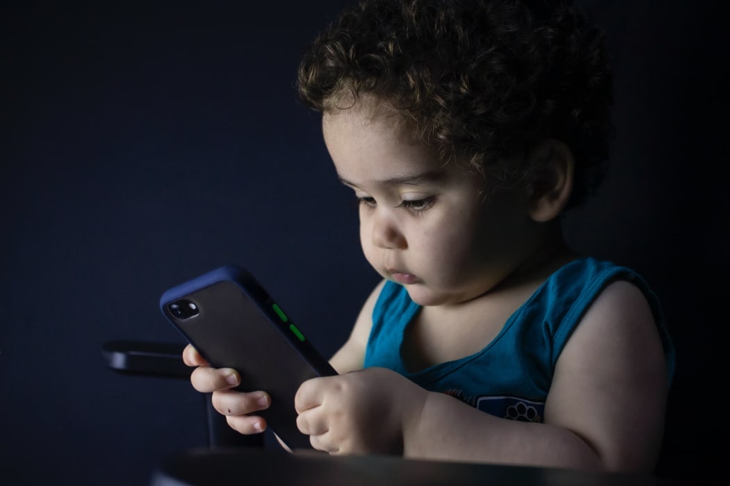 toddler with mobile phone
