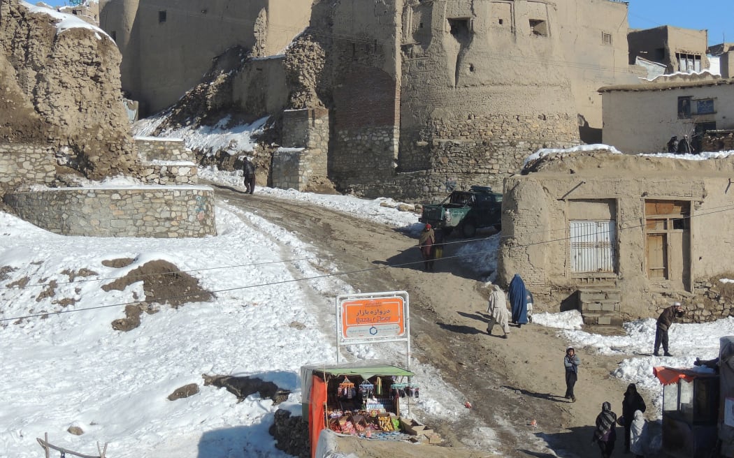 Pedestrians walk past a section of the old city as snow is pictured on the ground in Ghazni province on February 12, 2013. Ghazni, located in eastern Afghanistan along the Kabul-Kandahar road, is one of the thirty-four provinces and one of Afghanistan's major cities with an estimated population of 141,000 people.