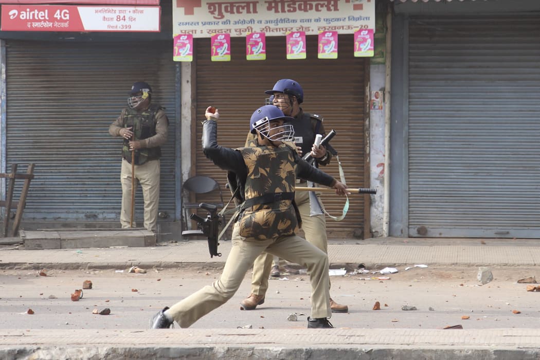 Police throw stones towards protesters during demonstrations.