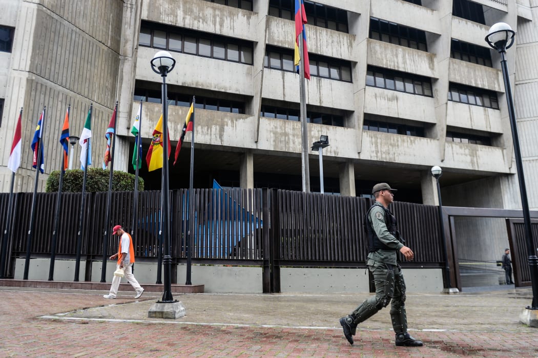 A member of the National Guard walks past the Supreme Court building in Caracas.