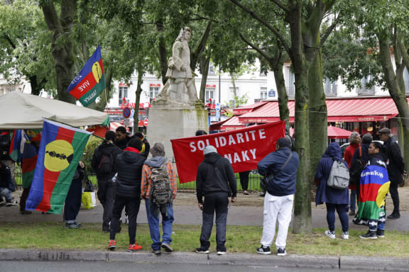 Protestors take part in a demonstration led by the Union of Kanak Workers and the Exploited (USTKE) and organisations of the Kanaky Solidarity Collective in support of Kanak people, with flags of the Socialist Kanak National Liberation Front (FLNKS) next to a statue of Vauban, amid a debate at the French National Assembly on the constitutional bill aimed at enlarging the electorate of the overseas French territory of New Caledonia, in Paris on May 14, 2024. France's prime minister on May 14, 2024, urged the restoration of calm in New Caledonia after the French Pacific archipelago was rocked by a night of rioting against a controversial voting reform that has angered pro-independence forces.