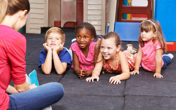 Teacher reading to preschoolers.