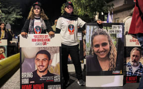 Protesters stand with portraits of Israeli hostages Rom Braslavski (20), Romi Gonen (23), and others during a demonstration by the families of the hostages taken captive in the Gaza Strip by Palestinian militants during the October 7, 2023 attacks, calling for action to release the hostages, outside the Israeli Prime Minister's residence in Azza (Gaza) Street in central Jerusalem on October 24, 2024 amid Israel's ongoing war with Hamas. (Photo by Ahmad GHARABLI / AFP)