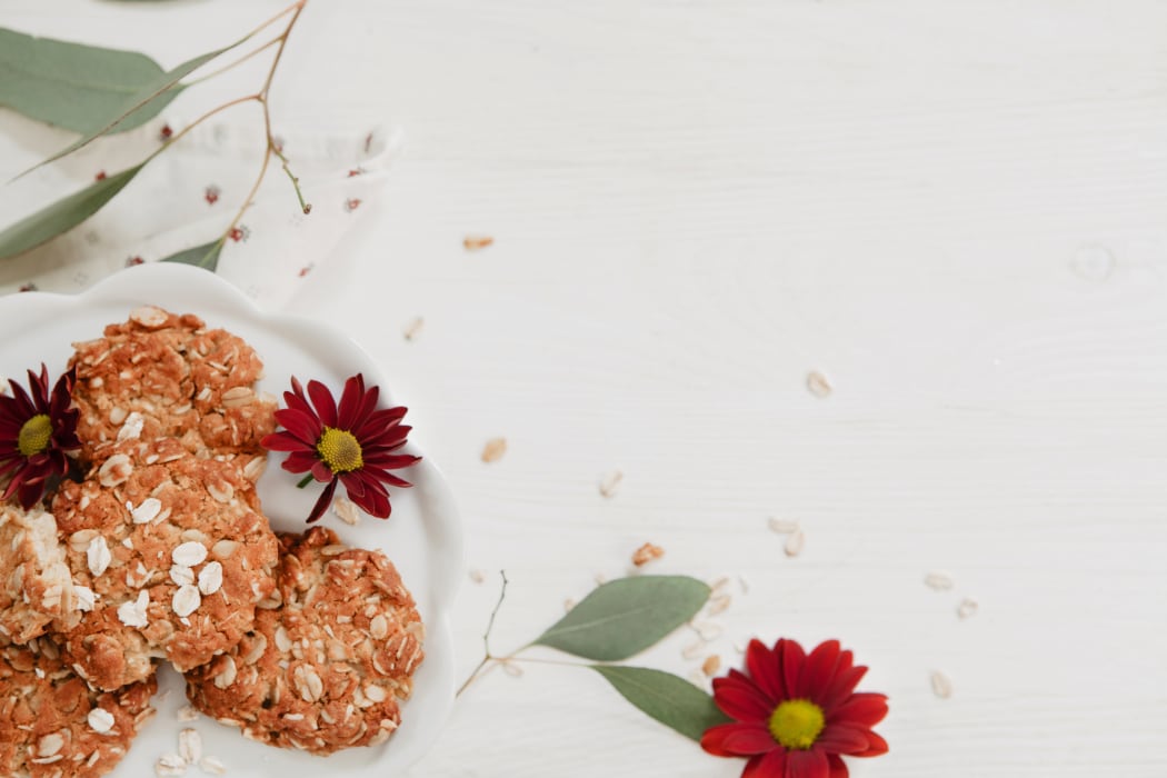 Homemade cookies on a white, wooden, rustic background with burgundy flowers