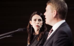 Jacinda Ardern looks at Chris Hipkins