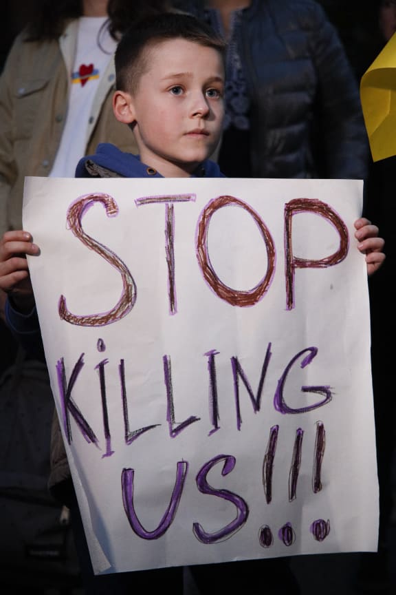 A boy holds a sign during a protest in Warsaw, Poland on 17 October, 2022. Several hundred people gathered in front of the Iranian embassy to protest the supply of loitering drones it calls Shahed drones to Russia, which Russia is using to attack Ukraine.