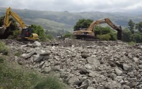 Diggers work in Roxburgh's Reservoir Creek drainage in a race against time before next the downpour.