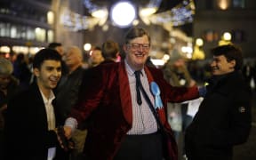 A Conservative Party supporter reacts with delight after the exit poll prediction of a win for PM Boris Johnson's Conservative Party.