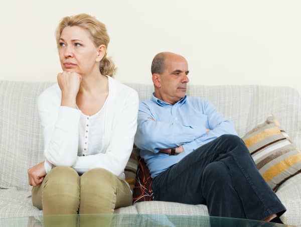 Angry mature married couple having quarrel at living room
